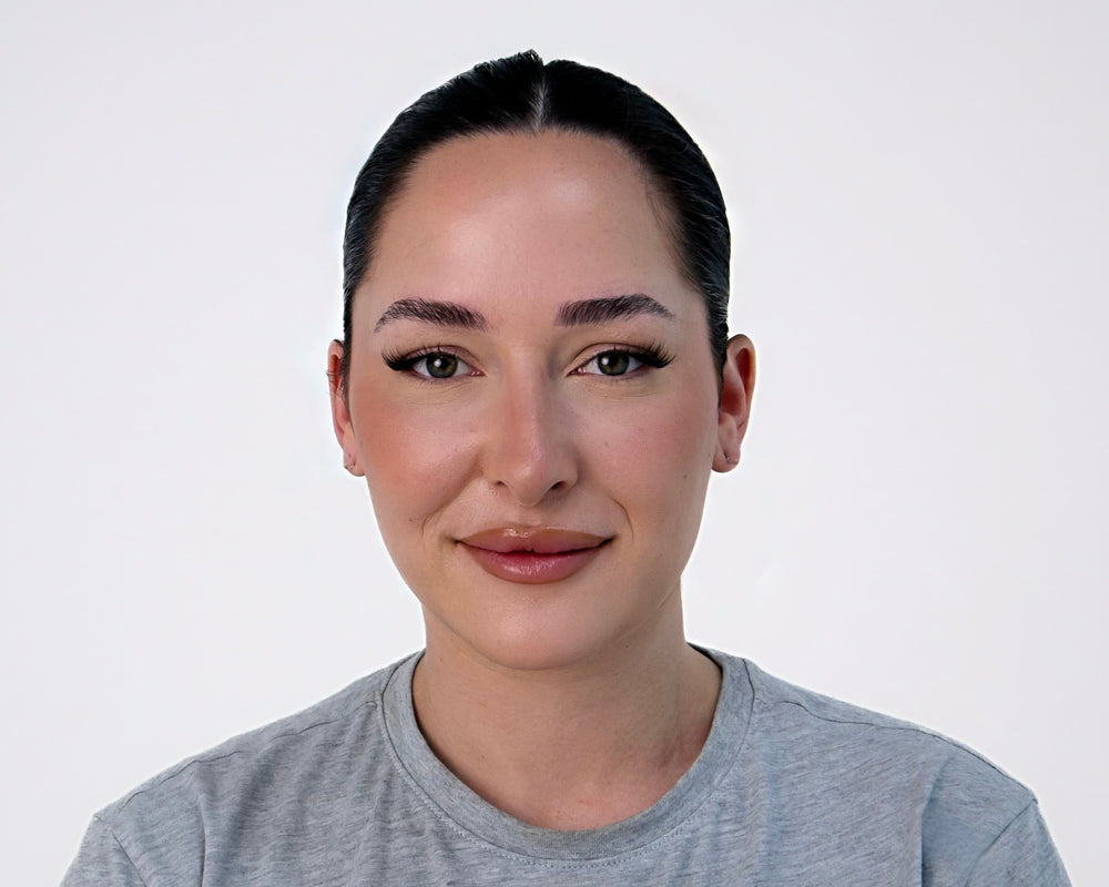 Person wearing a gray t-shirt against a white background with 1/4 lashes